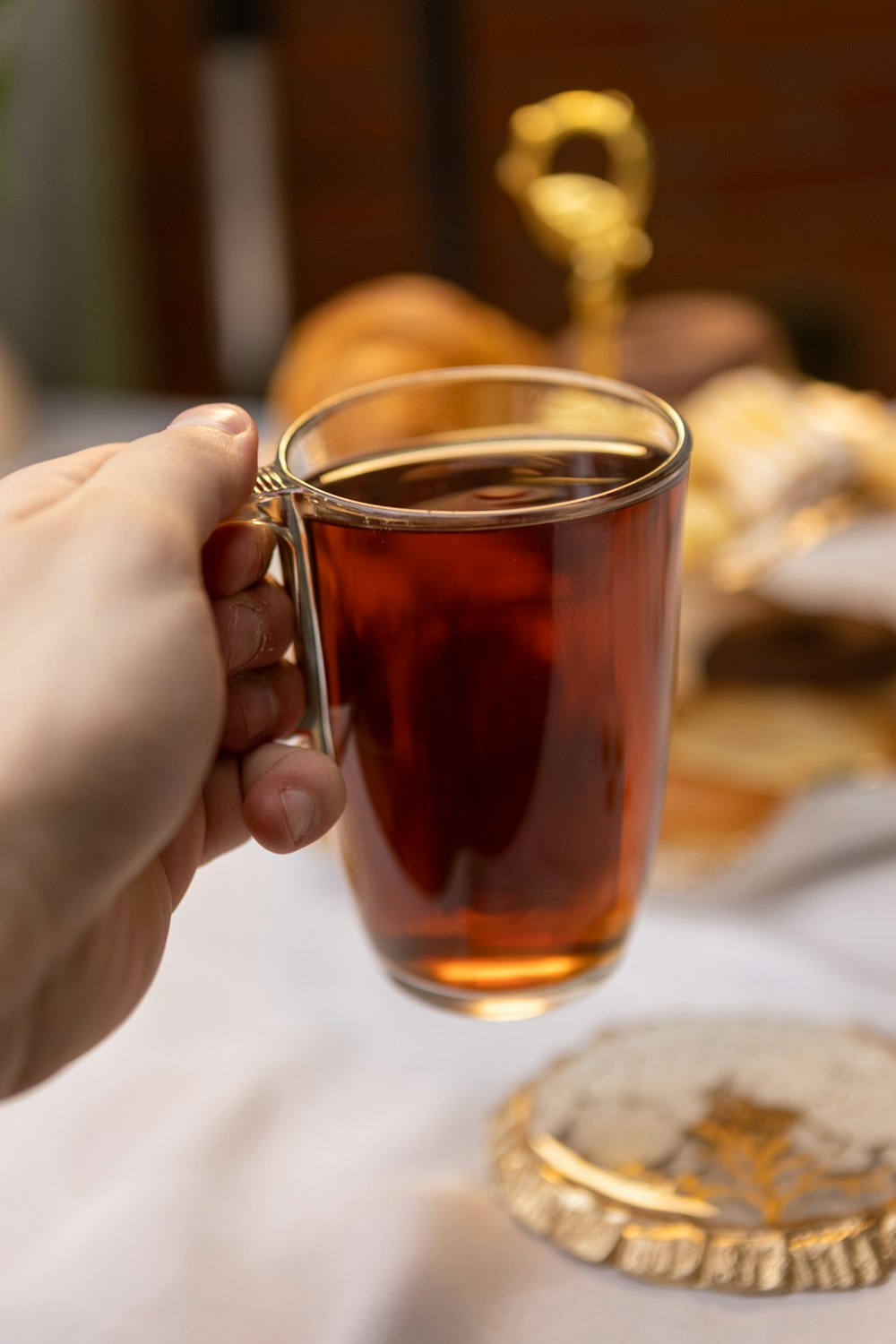 a person holding a cup of tea on a table