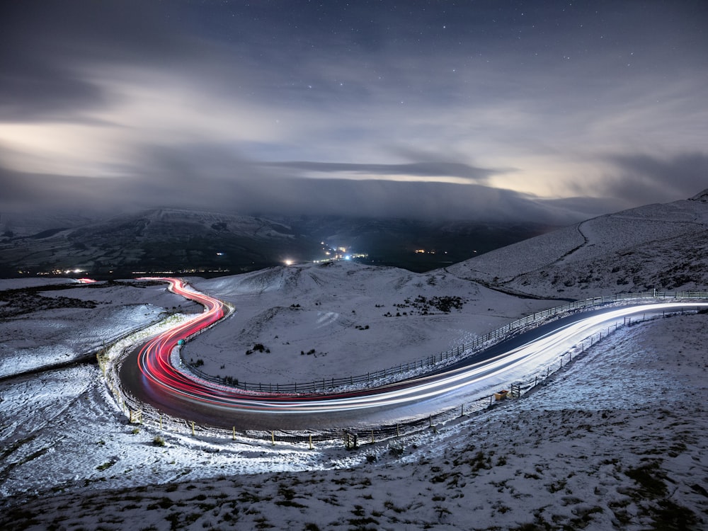 a long exposure photo of a road in the snow