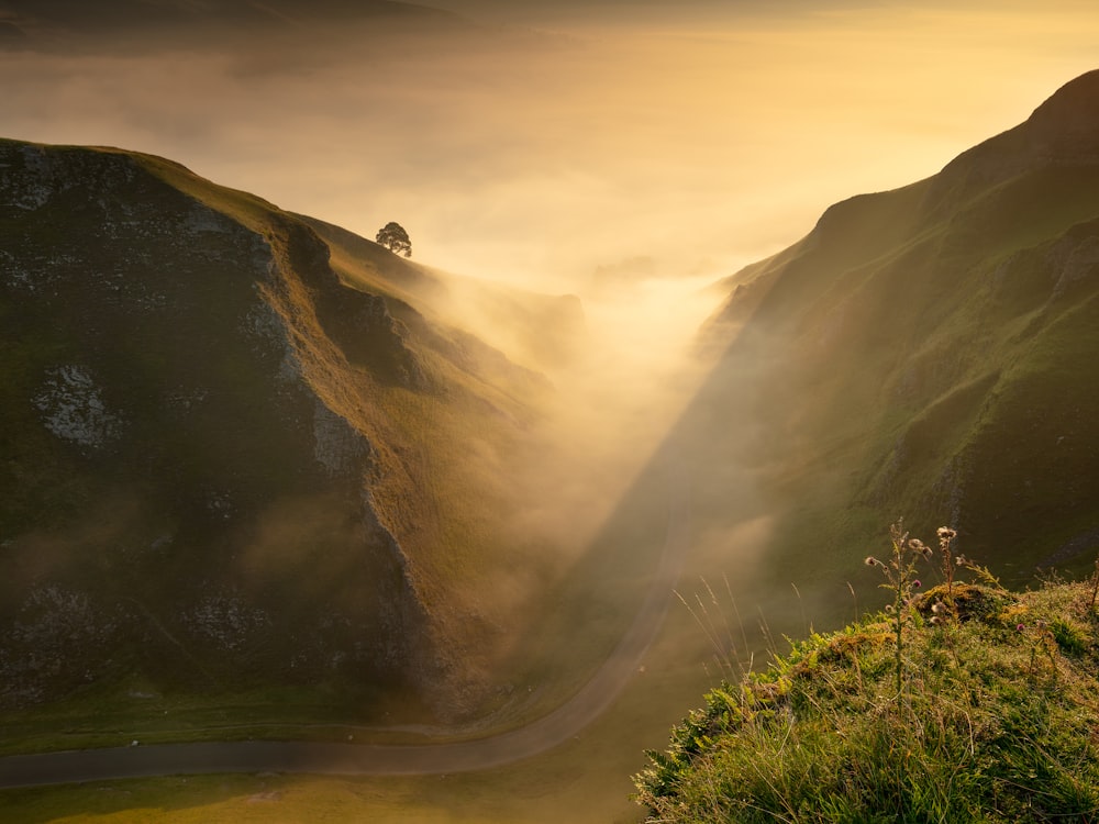 the sun shines through the fog in the mountains