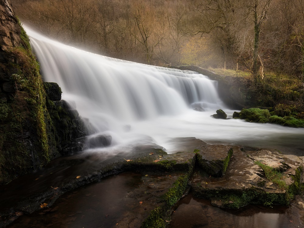 a waterfall with moss growing on the rocks