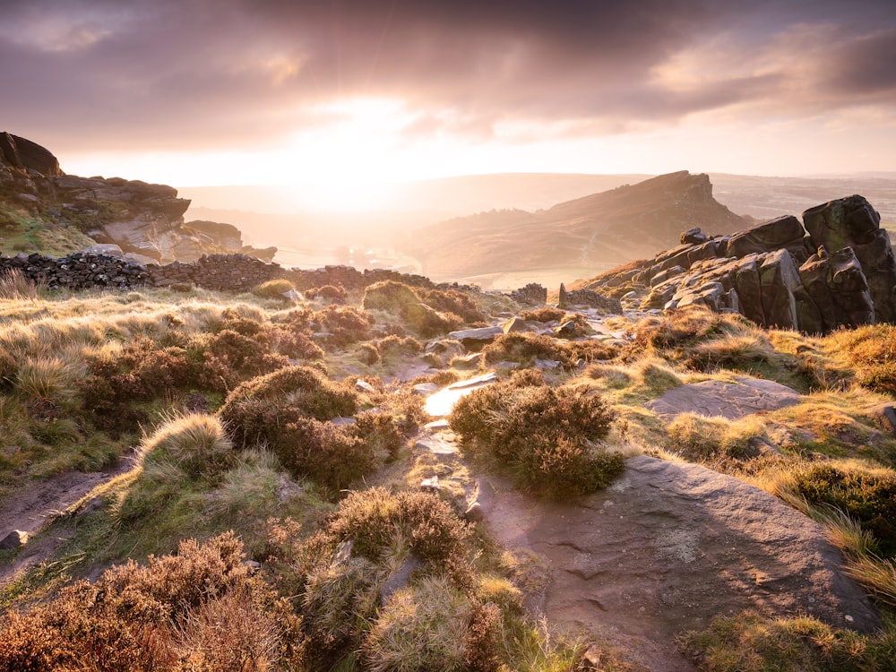 the sun is setting on the rocky terrain