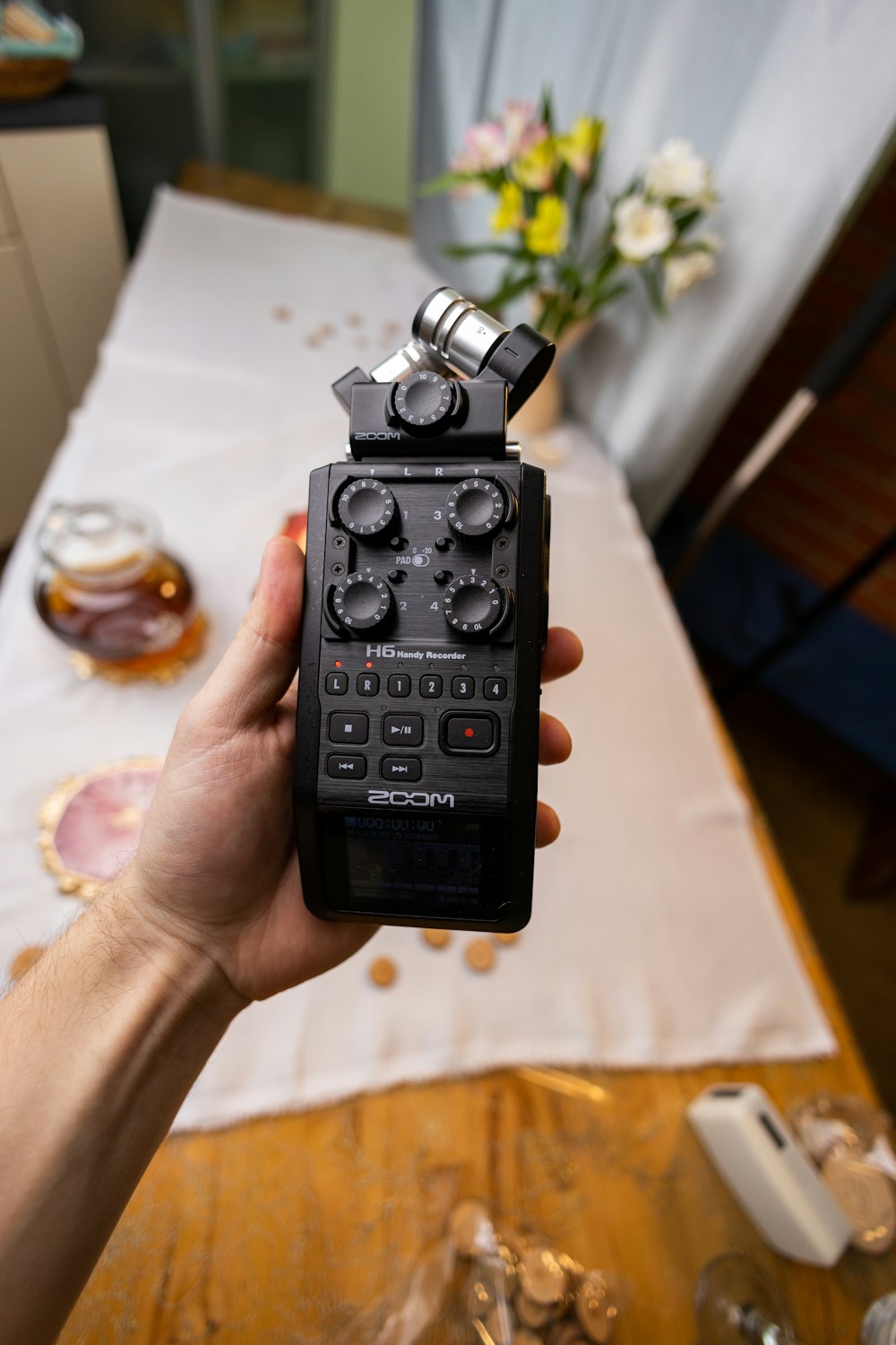 a person holding up a radio in front of a table