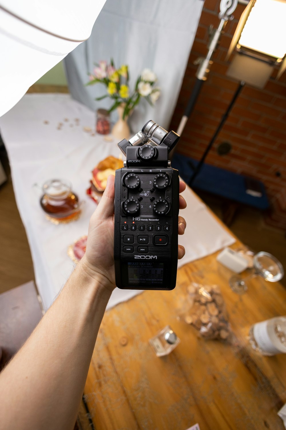 a person holding a remote control in front of a table