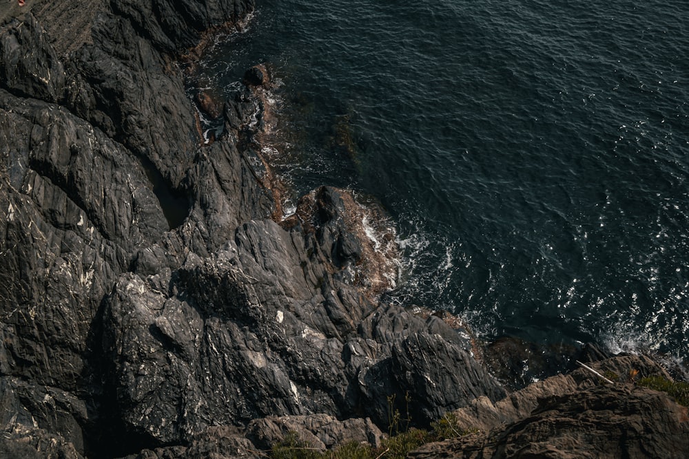 an aerial view of the ocean and rocks