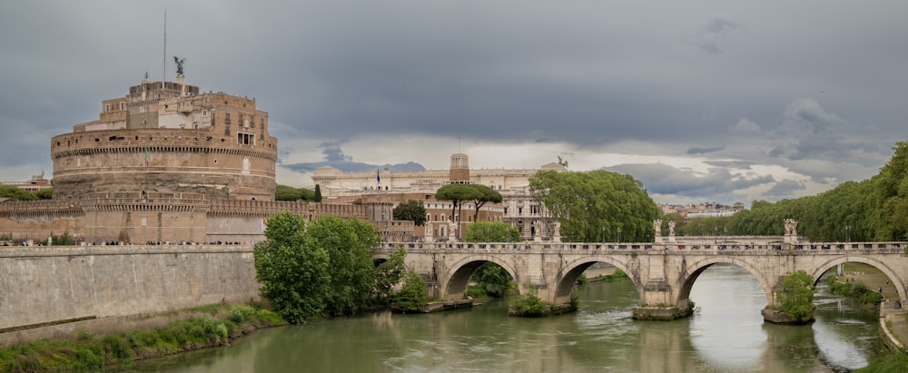 a bridge over a river with a castle in the background