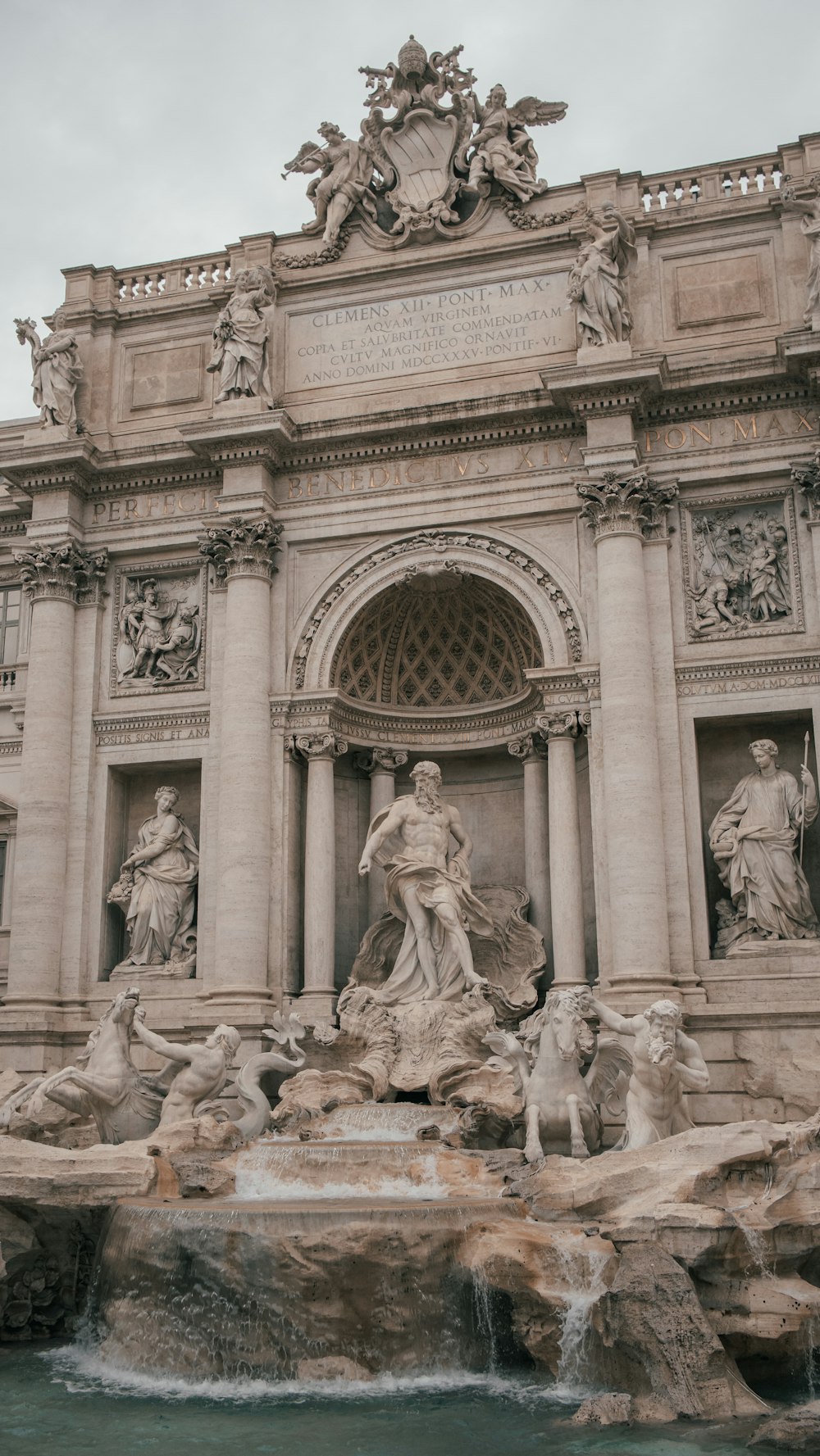 a fountain in front of a building with statues on it