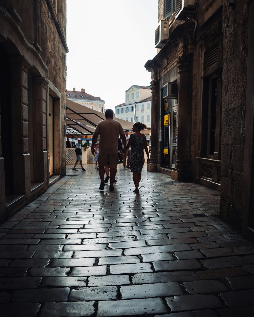 Un par de personas que están caminando por una calle