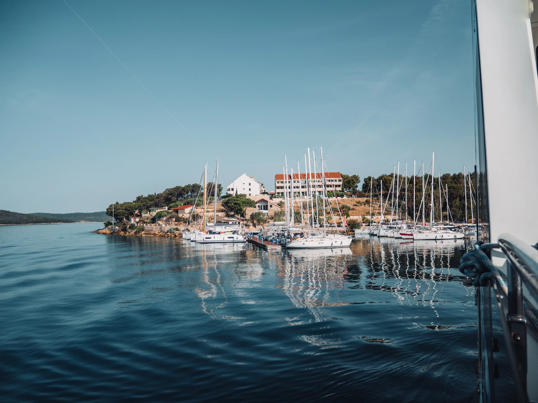 Boats rest in calm coastal water.
