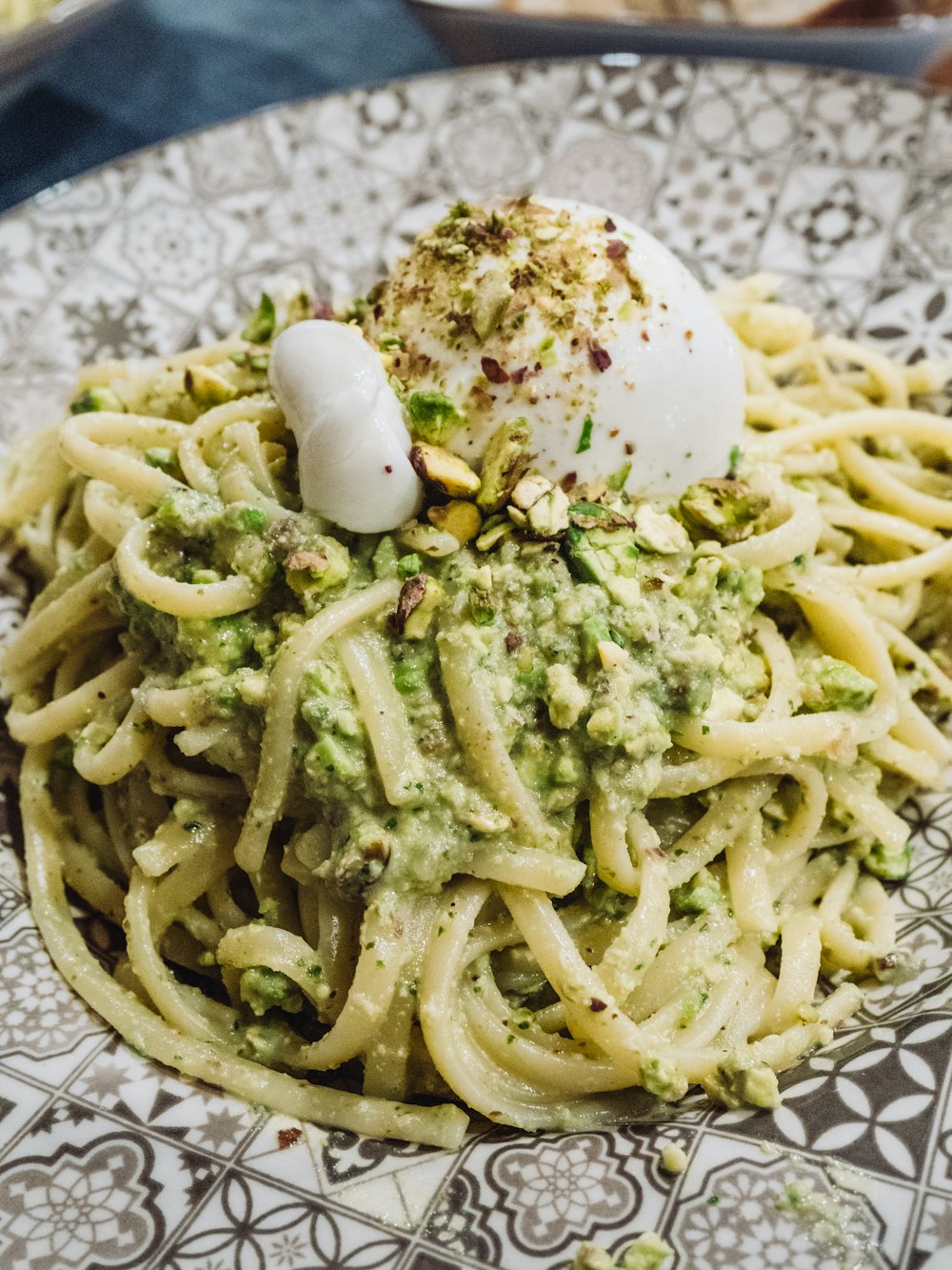 a plate of pasta with pesto and sour cream