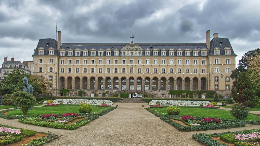 un grand bâtiment avec un jardin en face