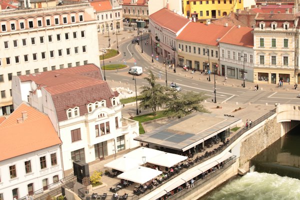 A river running through a city next to tall buildings — Oradea, Romania