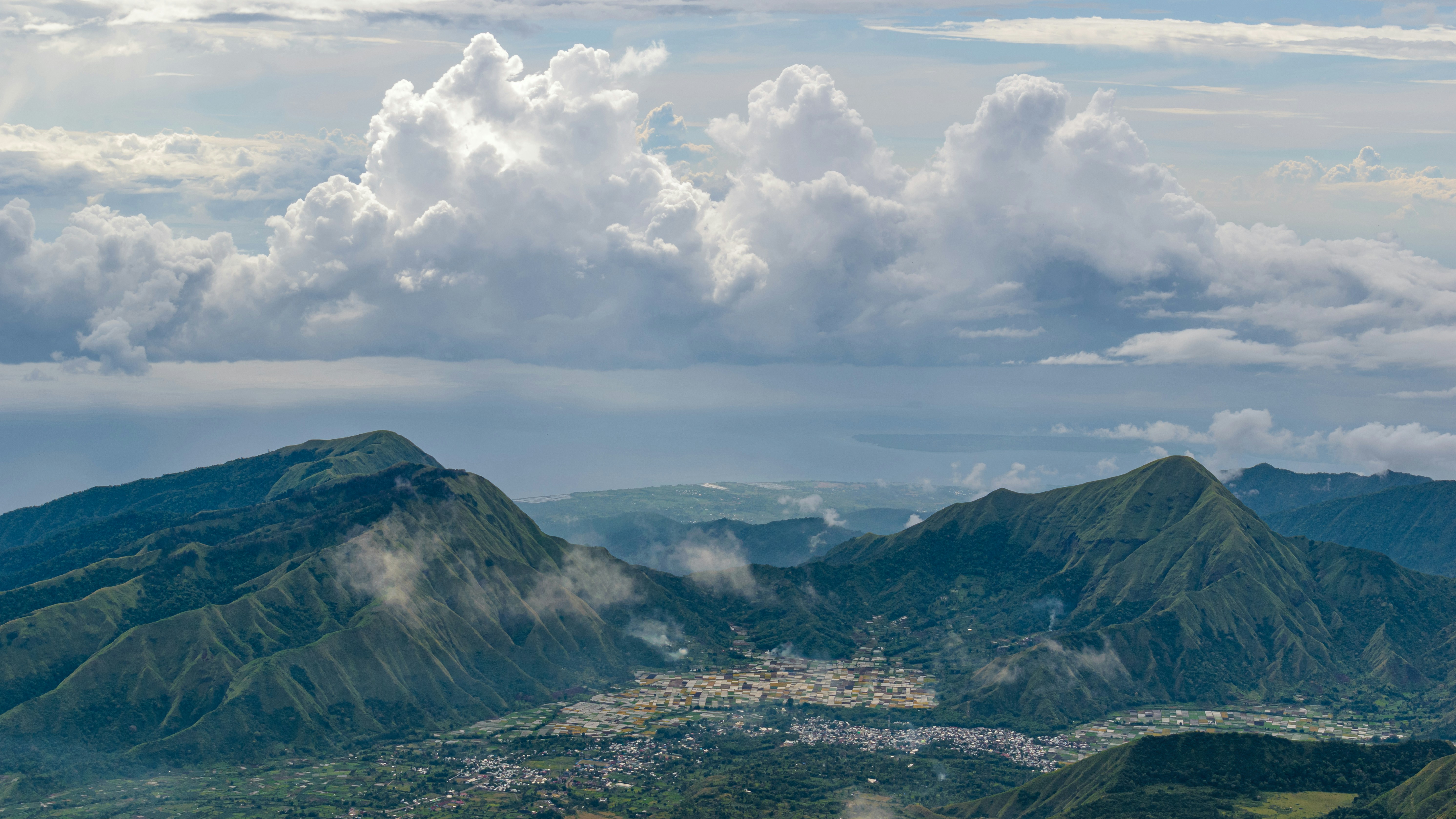 une vue d’une chaîne de montagnes avec des nuages dans le ciel
