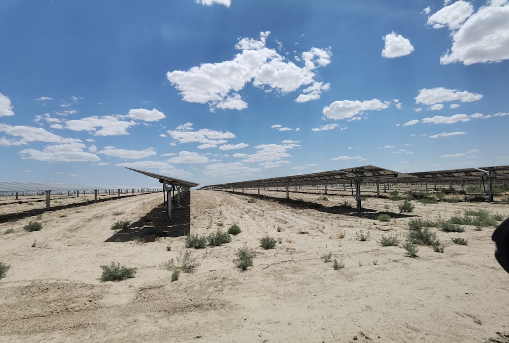 a row of solar panels in the middle of a desert