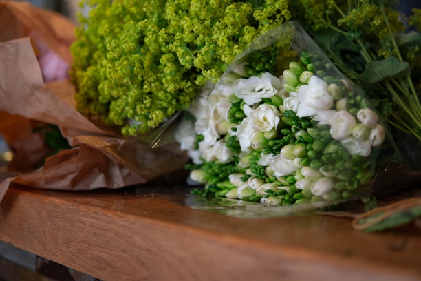 A close-up of a bouquet of fresh flowers wrapped in brown paper, showcasing their natural beauty.