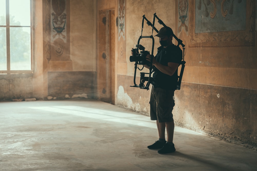 a man standing in a room holding a camera