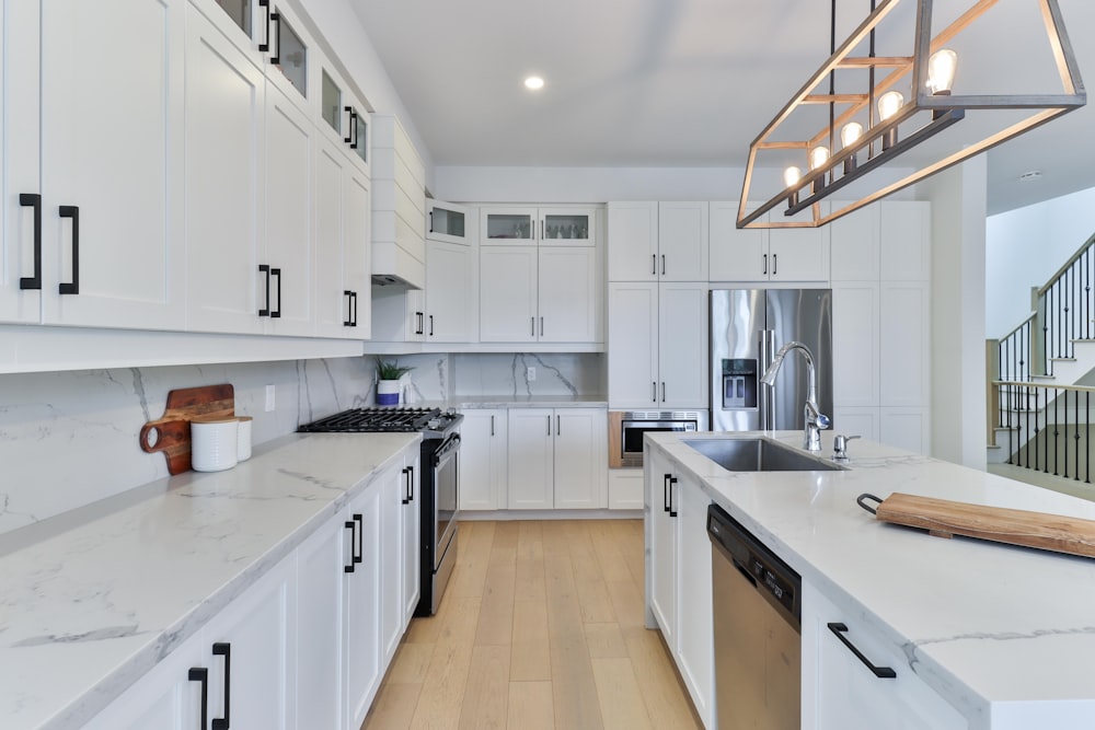 a kitchen with white cabinets and a wooden floor