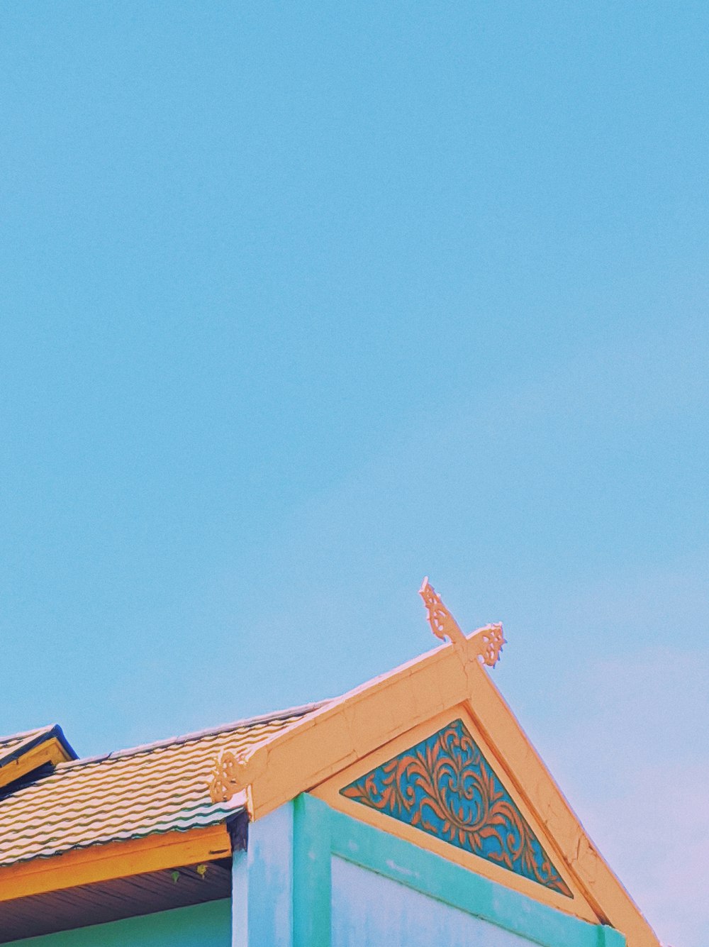 um relógio no topo de um edifício com um céu azul no fundo