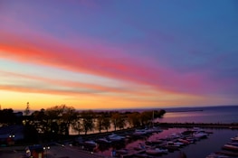 A serene view of boats docked at a marina during sunset.