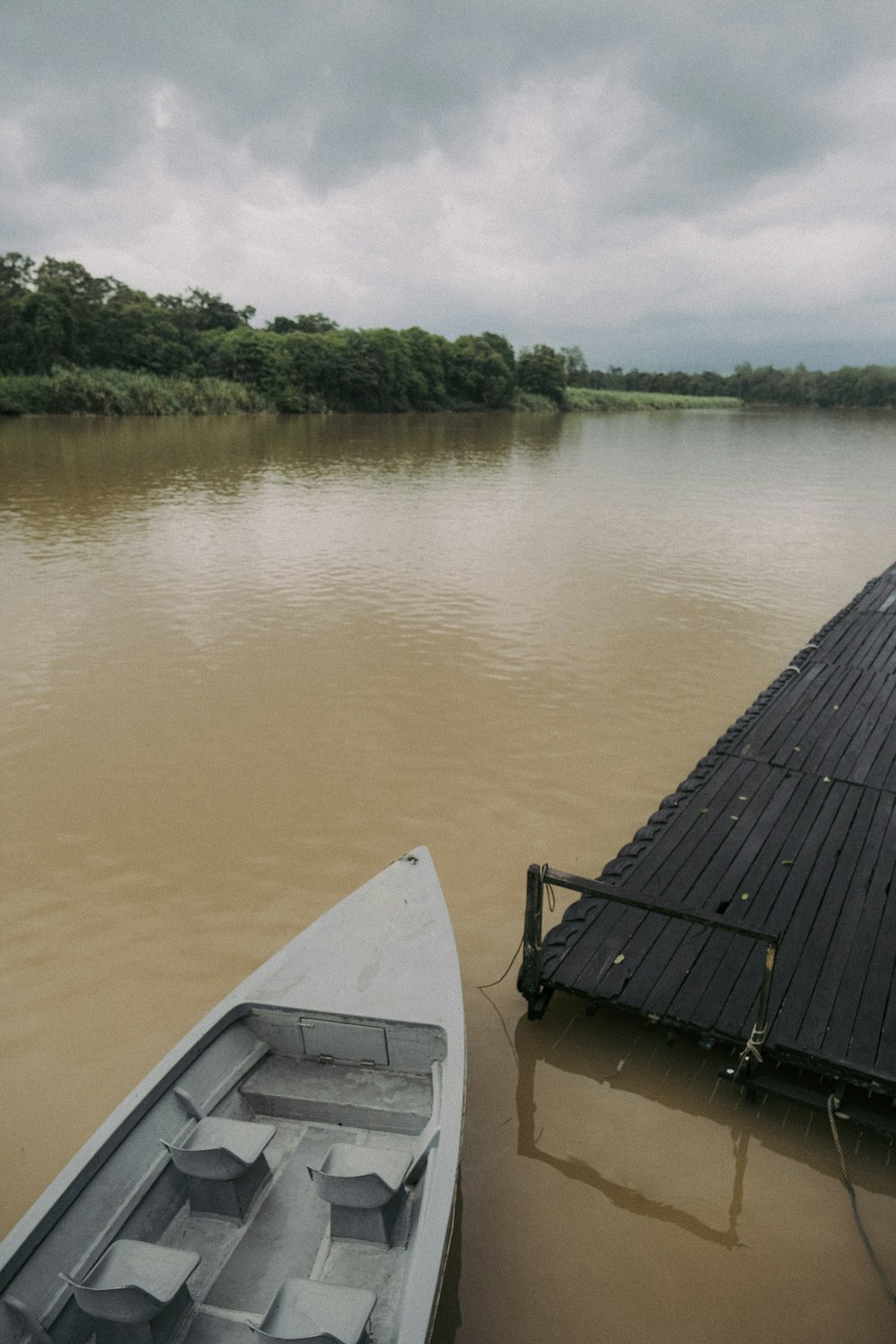 a boat sitting on top of a lake next to a dock