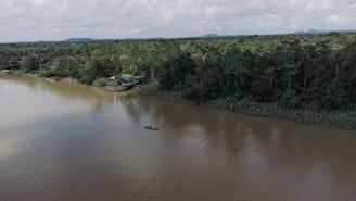 a boat floating on top of a lake surrounded by forest