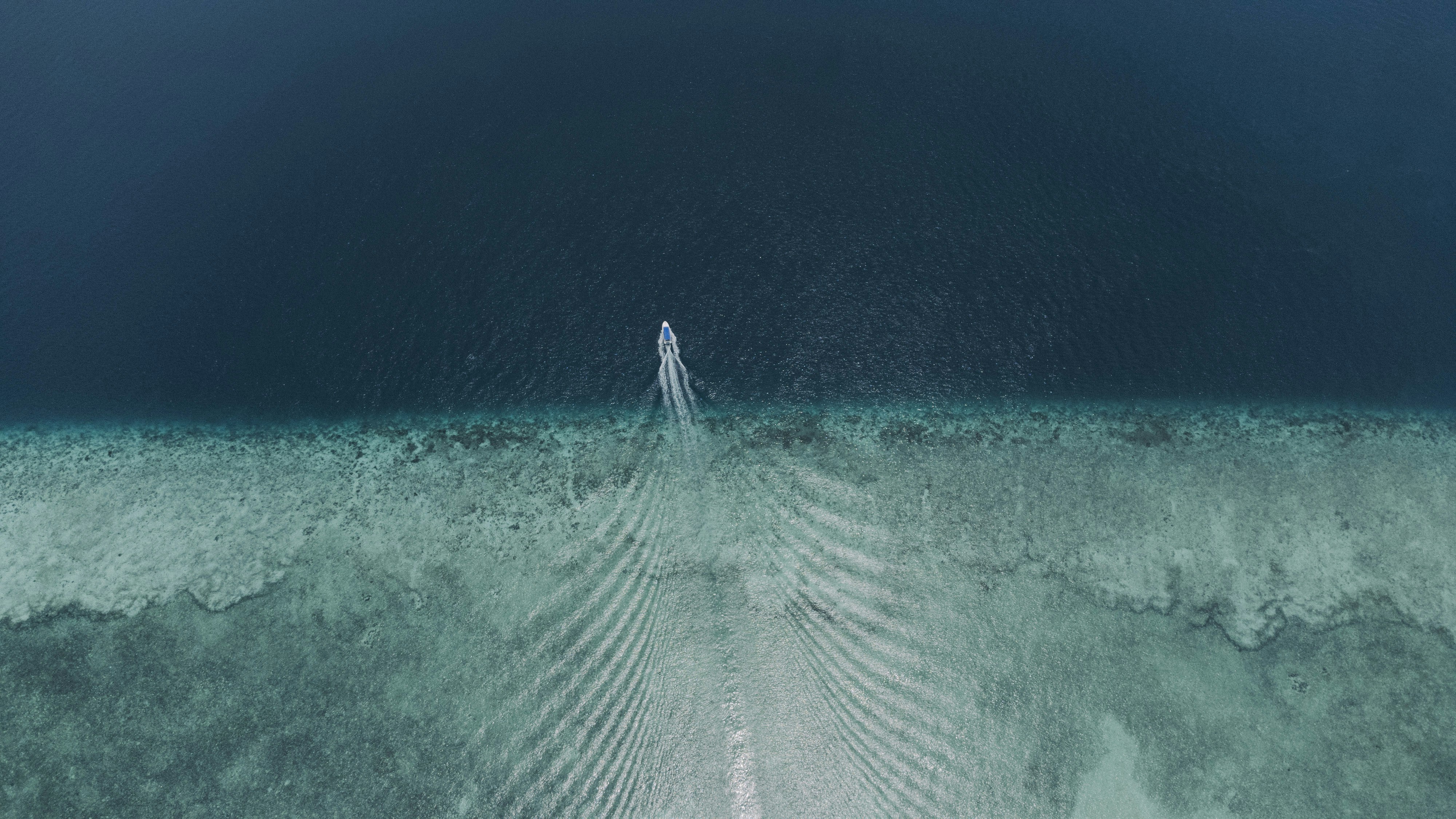 an aerial view of a boat in the ocean