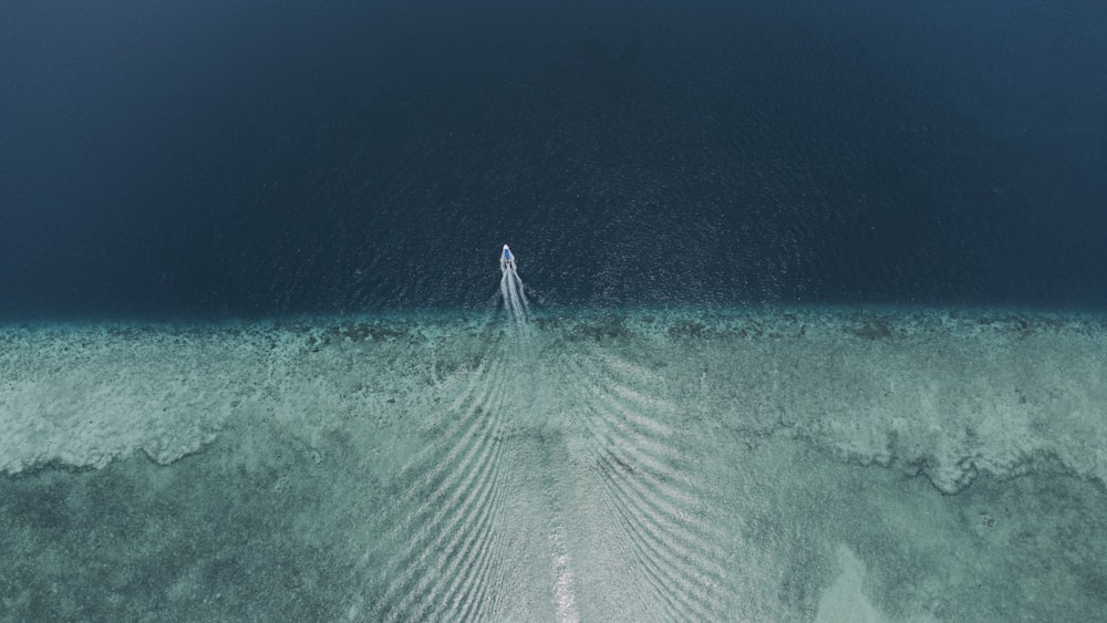 an aerial view of a boat in the ocean