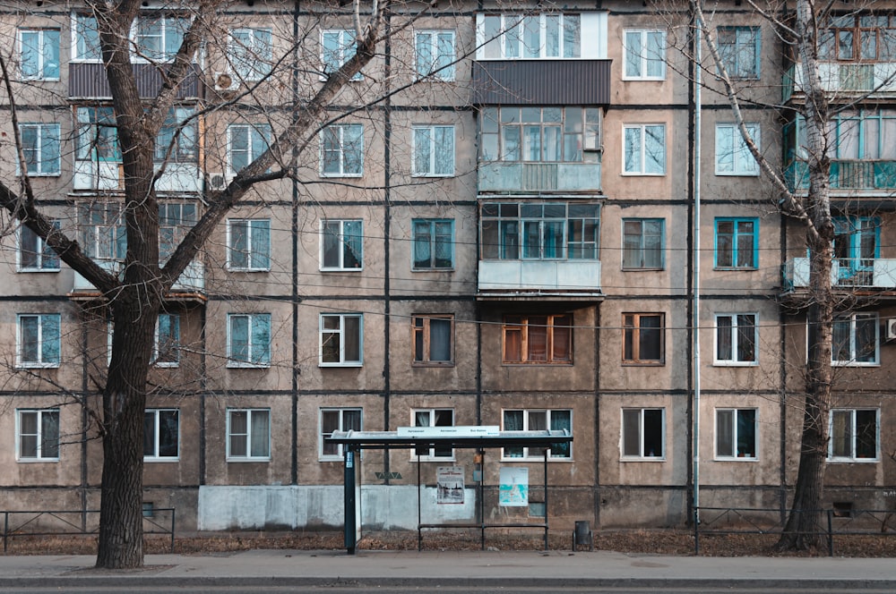 a bus stop sitting in front of a tall building