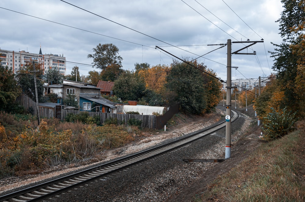 a view of a train track with houses in the background