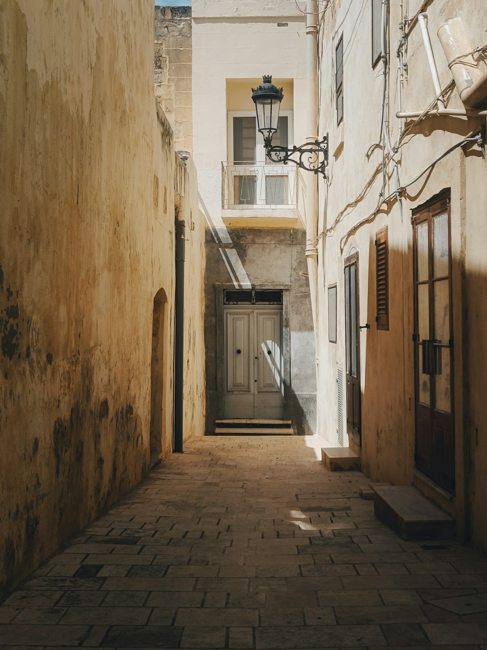 a narrow alley way with a door and a window