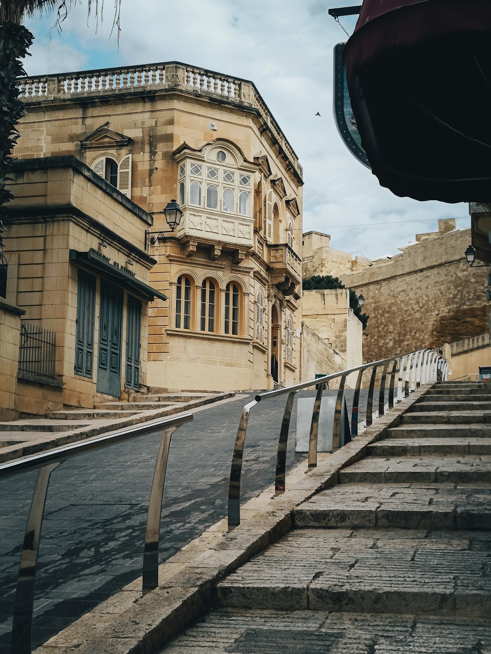 an old building with a balcony and stairs leading up to it