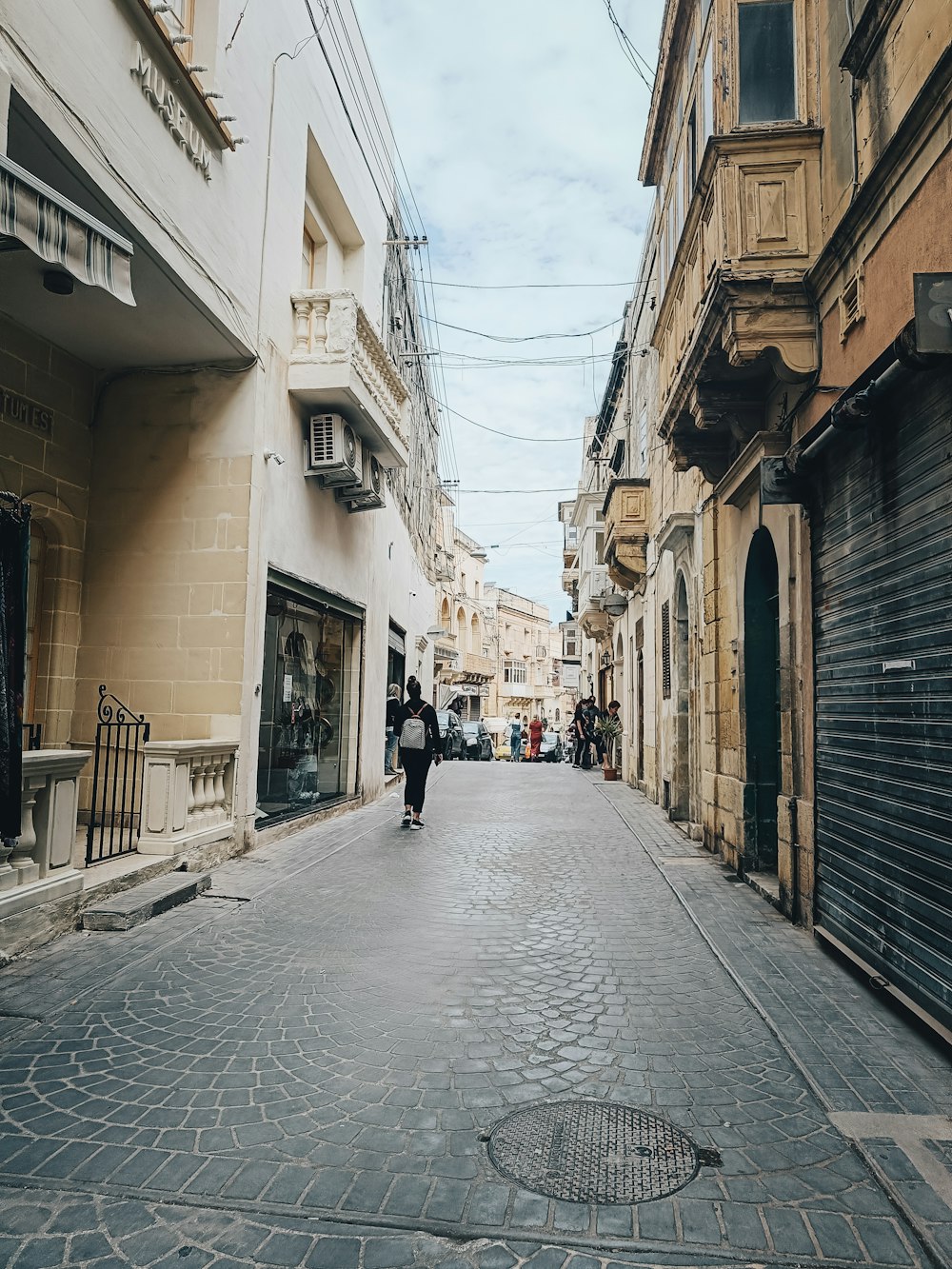 a man walking down a street next to tall buildings