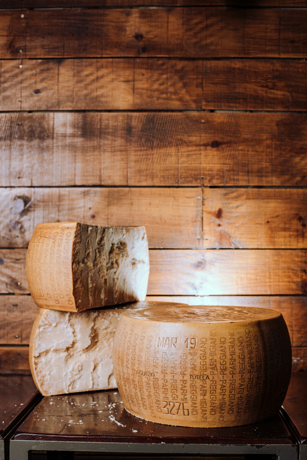 Un par de trozos grandes de queso sentados encima de una mesa