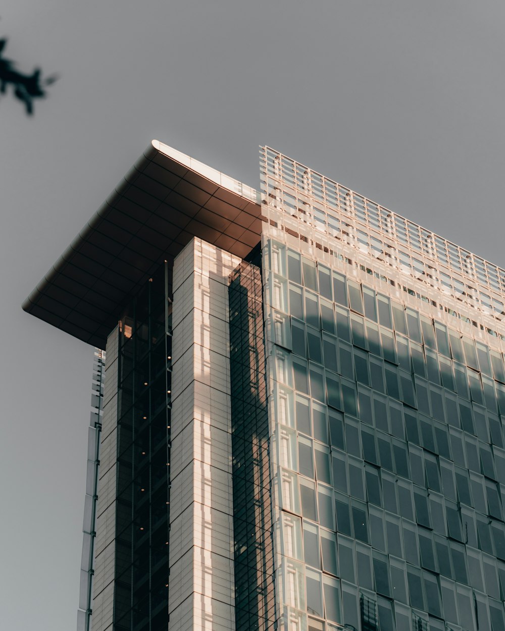 a plane flying in the sky over a tall building