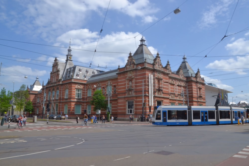 a blue and white train on a city street