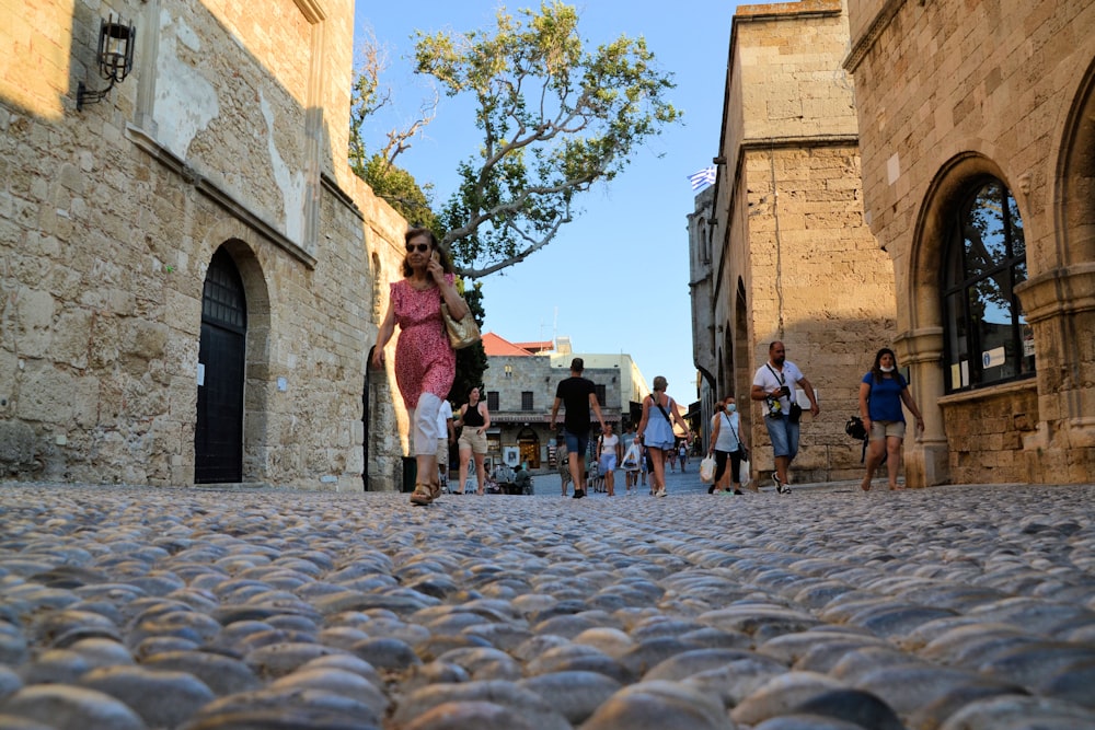 a group of people walking down a cobblestone street