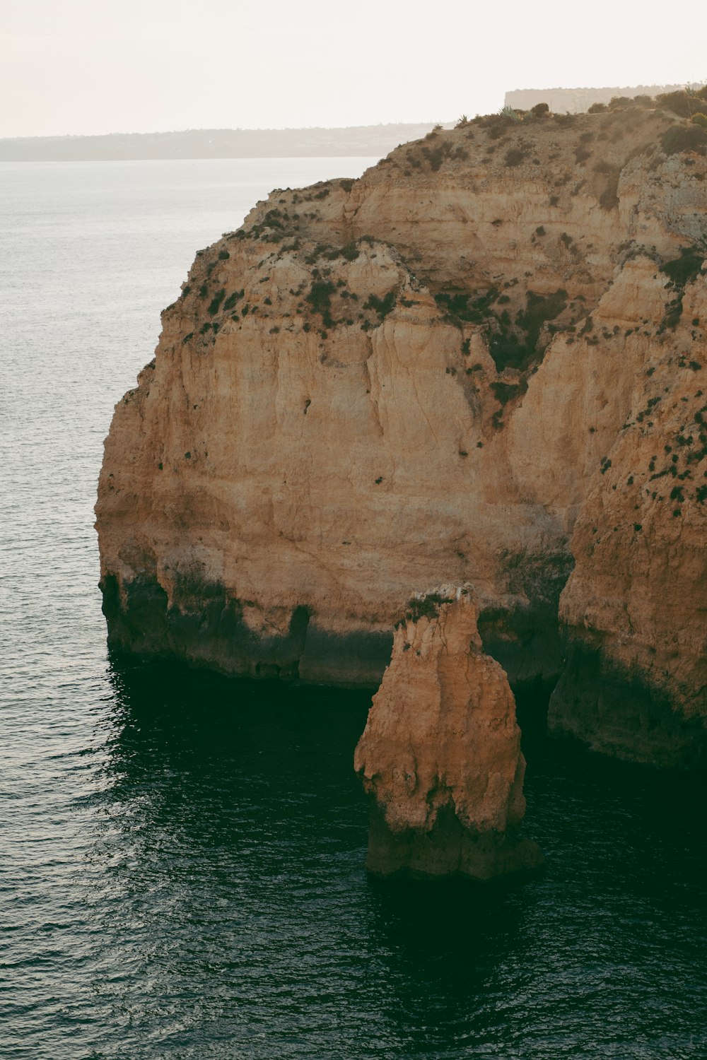 a rocky island in the middle of a body of water