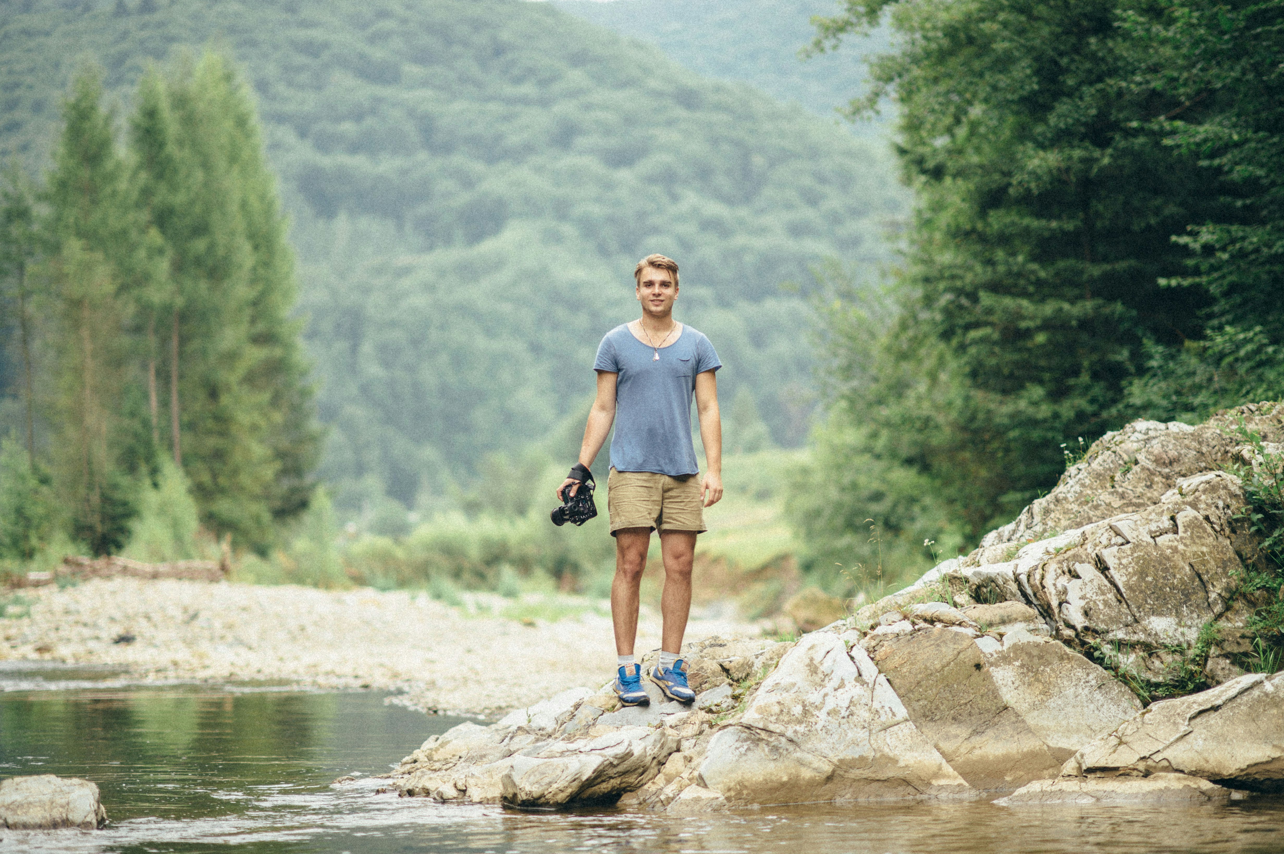 a man standing on a rock in the middle of a river
