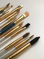 A variety of nail art brushes and tools laid out on a clean white surface.