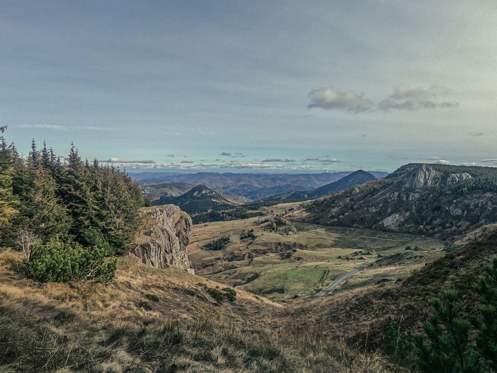 a scenic view of a valley with mountains in the background