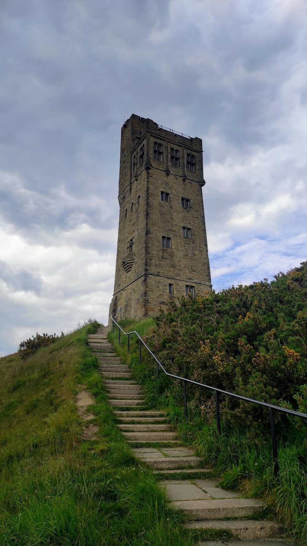 uma torre muito alta sentada no topo de uma encosta verde exuberante