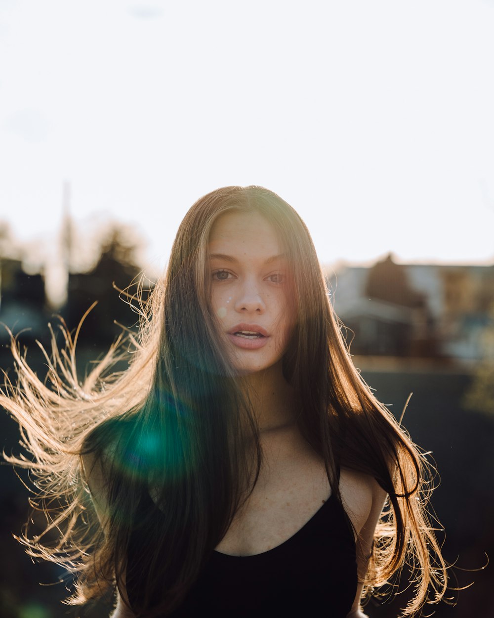 a woman with long hair standing in the sun