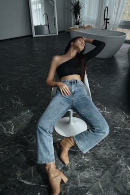 a woman sitting on a chair in a bathroom