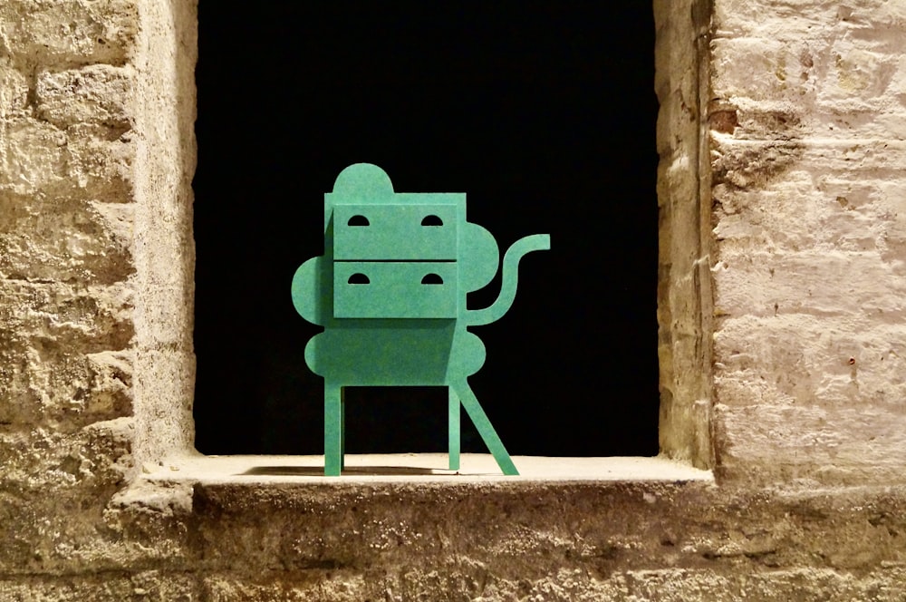 a paper cut out of a robot sitting in a window