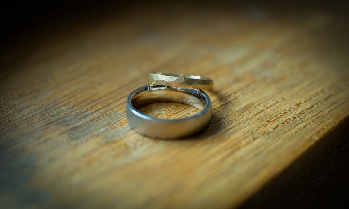 Dua cincin kawin di atas meja kayu