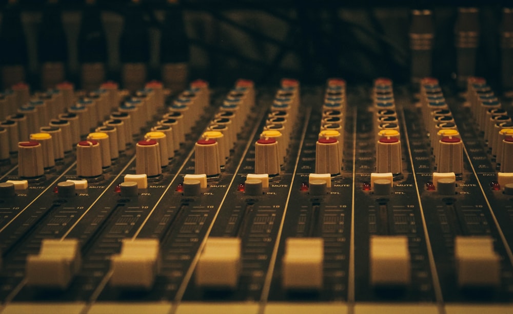 a close up of a sound board with many knobs