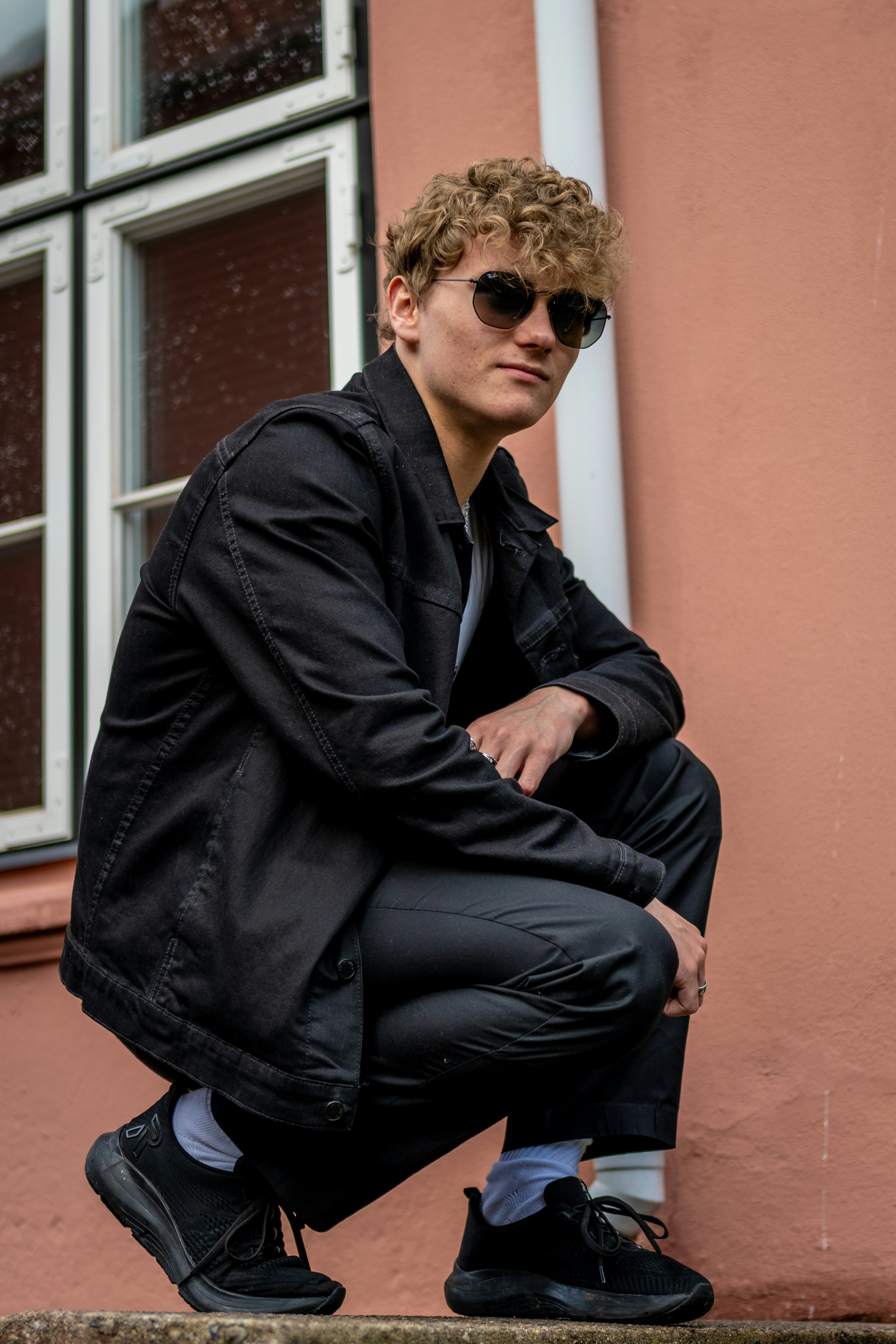 great photo recipe,how to photograph young adult portrait; a man in a black jacket and sunglasses sitting on a step