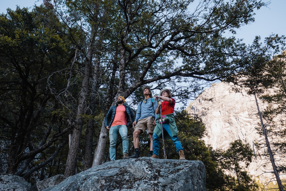 a group of people standing on top of a rock