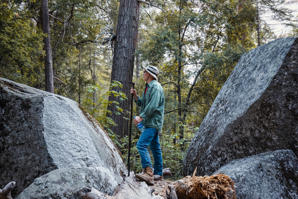 a man standing on a rock in the woods