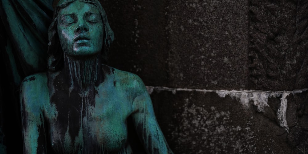 a statue of a woman covered in green paint