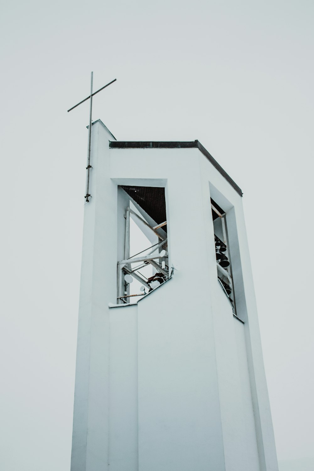 a tall white tower with a cross on top of it